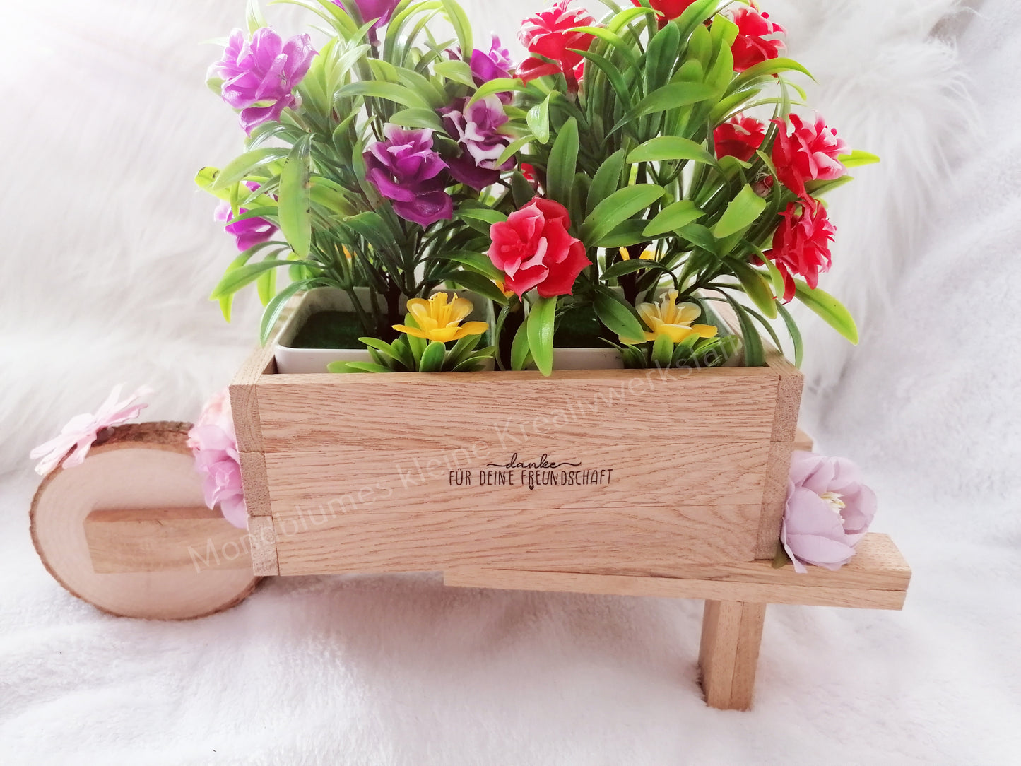 Schubkarre hell, befüllt mit Blumen