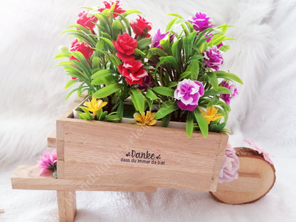 Schubkarre hell, befüllt mit Blumen